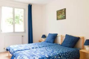 um quarto com uma cama com lençóis azuis e uma janela em Vue Paris (&tour Eiffel), Maison indépendante em Suresnes