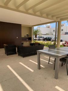 patio con mesa y sillas y aparcamiento en Enjoy Cancun, en Cancún