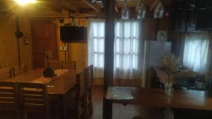 een eetkamer met een tafel en een tafel en een keuken bij Cabañas en los reartes in Los Reartes +21 foto's