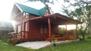 een houten hut met een tafel en een groen dak bij Cabañas en los reartes in Los Reartes