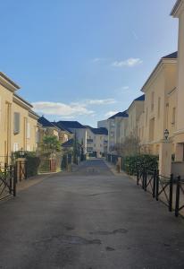 eine leere Straße mit Häusern und einer Auffahrt in der Unterkunft Résidences HAR in Élancourt
