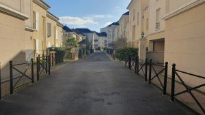 une rue vide avec des bâtiments et une clôture dans l'établissement Résidences HAR, à Élancourt