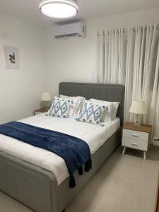 1 dormitorio con 1 cama con almohadas azules y blancas en Residencial Mediterraneo, en Santiago de los Caballeros