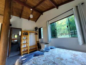 1 dormitorio con cama y ventana grande en Refúgio Tao Cerrado Chalé Brisa Da mata en Alto Paraíso de Goiás