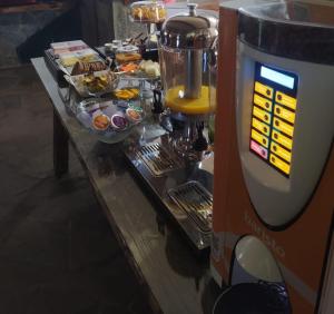 Hibisco Home Hotel في أوروبيسي: بوفيه مع وجود ماكينة مشروبات على طاولة طعام