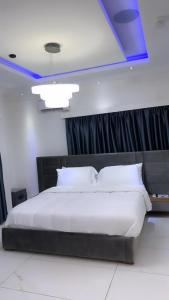 a bedroom with a large bed with a blue ceiling at Bash luxury apartments in Freetown