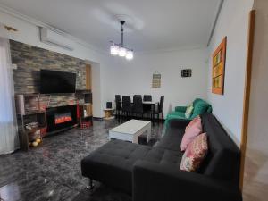 a living room with a couch and a tv at Casa Rural Oasis, una casa rural en Puertollano, agradable, con Piscina en zona tranquila in Puertollano