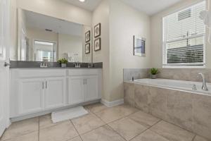 a bathroom with a large tub and a large mirror at Lovely Condos 18 Minutes away from Disney! in Kissimmee