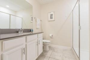 y baño con aseo, lavabo y ducha. en Lovely Condos 18 Minutes away from Disney!, en Kissimmee