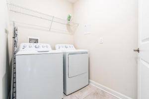 uma lavandaria branca com máquina de lavar e secar roupa em Lovely Condos 18 Minutes away from Disney! em Kissimmee