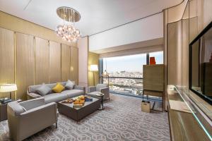 a living room with a couch and a table at Narcissus The Royal Hotel in Riyadh