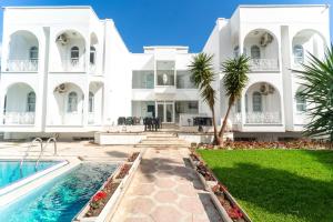 een groot wit huis met een zwembad en een tuin bij Kemer Royal Beach Hotel in Kemer