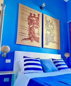 1 dormitorio azul con 1 cama y 2 posters en la pared en Qurchiti, en Capo dʼOrlando