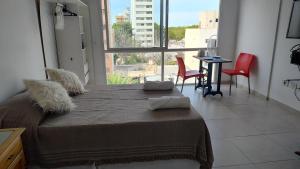 Imagine Depto في لا بلاتا: غرفة نوم بها سرير ونافذة كبيرة