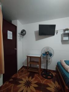 a room with a room with a fan and a table at Soinca Backpacker Hospedaje in Paracas