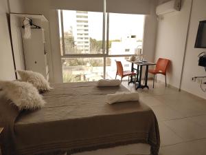 Imagine Depto في لا بلاتا: غرفة نوم بسرير كبير وطاولة مع كراسي