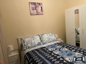 een slaapkamer met een bed met een blauw en wit dekbed bij Joli appartement balnéaire avec piscine in Tanger