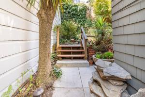 a patio with a wooden bench next to a tree at Secret Garden Stay - Perfect SF Location in San Francisco