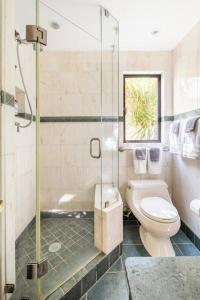 a bathroom with a toilet and a glass shower at Secret Garden Stay - Perfect SF Location in San Francisco