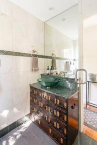 a bathroom with a green sink and a mirror at Secret Garden Stay - Perfect SF Location in San Francisco