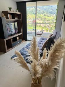 a living room with a couch and a vase with feathers at Moderno Apartamento en Sabaneta / Medellín in Sabaneta