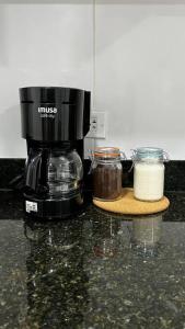 - une cafetière et deux bocaux sur un comptoir dans l'établissement Moderno Apartamento en Sabaneta / Medellín, à Sabaneta
