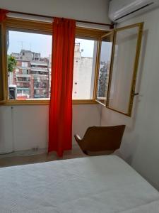 een slaapkamer met een bed en een rood gordijn bij Ciudad de Bs As in Buenos Aires
