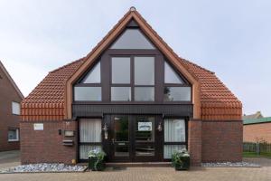 une petite maison avec un toit triangulaire dans l'établissement Fewo-Gyde-3-Haustiere-erlaubt-WLAN-kostenlos, à Norddeich