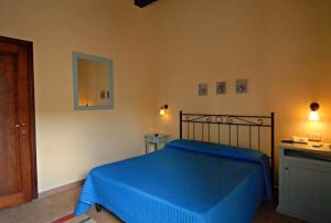 una camera da letto con un letto blu e uno specchio di Podere Turicchio a Orbetello
