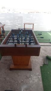 a large wooden foosball table sitting next to the water at Soinca Backpacker Hospedaje in Paracas