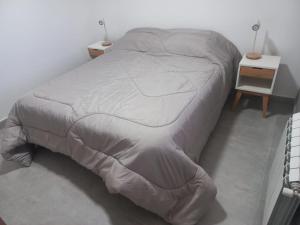 a bed with a white comforter in a bedroom at Villa las Marias in San Carlos de Bariloche