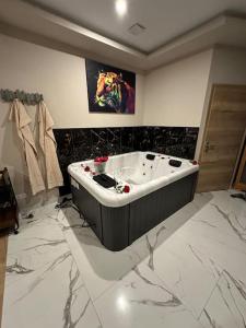 een badkamer met een groot bad in een kamer met marmeren vloeren bij Spa_Herrlisheim in Herrlisheim