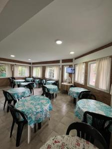 a restaurant with tables and chairs and a television at Hotel Aimara in Mina Clavero