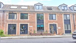 a brick building with two benches in front of it at Great North Getaways - Newcastle upon Tyne in Jesmond