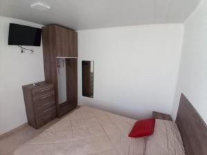 1 dormitorio con 1 cama, vestidor y TV en Alojamiento en Chajarí en Chajarí