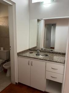 a bathroom with a sink and a mirror at Hotel Aimara in Mina Clavero