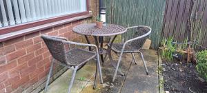 een tafel met twee stoelen en een tafel met een plant bij Home Paradise Manchester- 3 Bedroom House in Manchester