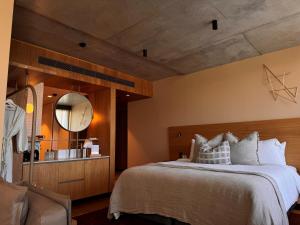 1 dormitorio con 1 cama grande y espejo en Hotel Marvell Byron Bay, en Byron Bay