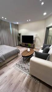 un soggiorno con letto, divano e tavolo di استوديو انيق وهادئ بتصميم بوهيمي a Riyad