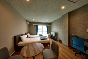 宮古島にあるHotel CABANA カバナ 宮古島のベッドルーム1室(ベッド1台、デスク、テーブル付)