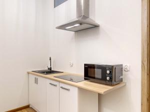 una cucina con forno a microonde e lavandino di roomspoznan pl - Apartamenty i Pokoje Półwiejska 20 - 24h self check-in a Poznań