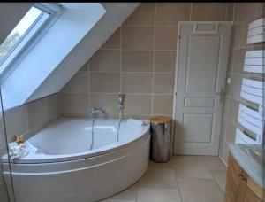 baño con bañera grande y ventana en Les Bécasses, en Merlimont