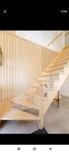 una escalera de madera en una sala de estar con barandilla de madera en Les Bécasses, en Merlimont