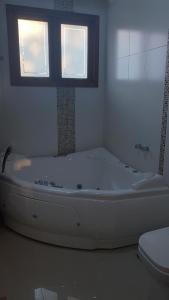 a white bath tub in a bathroom with a window at Marina Casa de campo in Santa Maria