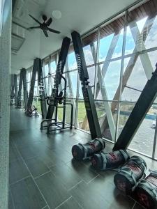 - une salle de sport avec plusieurs tapis de course dans une pièce dotée de fenêtres dans l'établissement Az Homestay @ Residensi Adelia 2, à Kajang