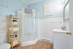 a bathroom with a shower and a toilet and a sink at Pepperell Place Inn Inc. in St. Peter's