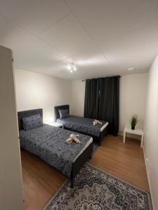 a small room with two beds and a rug at Noah Longstay Stratosfärgatan 15 in Gothenburg