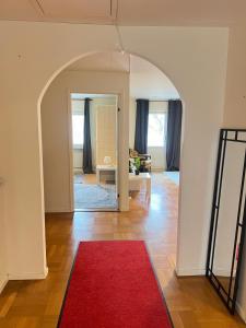 an archway in a living room with a red rug at Noah Longstay Stratosfärgatan 15 in Gothenburg