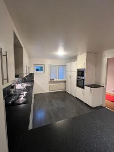 uma grande cozinha com armários brancos e uma bancada em Noah Longstay Stratosfärgatan 15 em Gotemburgo