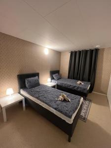a room with two beds and two tables at Noah Longstay Stratosfärgatan 15 in Gothenburg